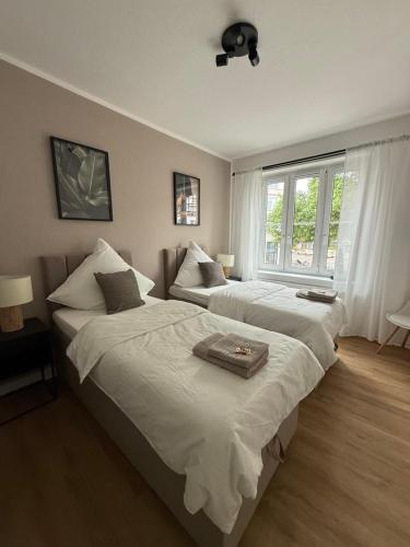 ein Schlafzimmer mit zwei Betten und einem Fenster in der Unterkunft Apartment 1 Urban Vibe in Hannover