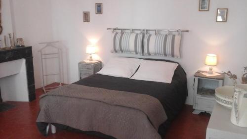 um quarto com uma cama e duas lâmpadas em duas mesas em Le Presbytère em Rivesaltes