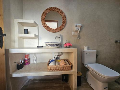 a bathroom with a sink and a toilet and a mirror at Casa de Mima, Casa Rural in Restinga Smir