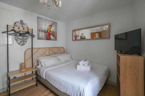une chambre avec un lit et une télévision à écran plat dans l'établissement French typical apartment (opéra 5D), à Paris