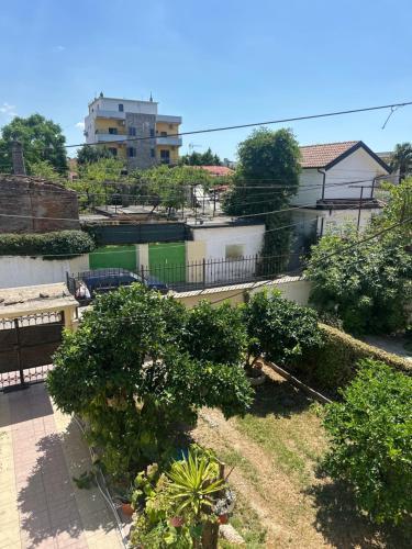 Una vista de un jardín con árboles y edificios. en Maison, en Polisi i Vogël