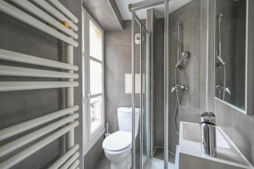 une salle de bain avec toilettes et douche en verre dans l'établissement French typical apartment (opéra 5D), à Paris