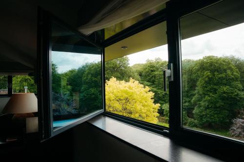 a window in a room with a view of trees at Hotel Gastronomique de Echoput in Apeldoorn