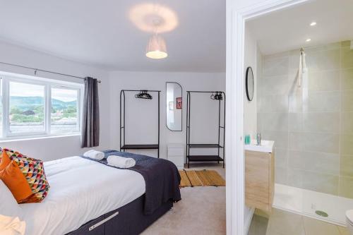 a bedroom with a large bed and a bathroom at The Art House Ruthin - 3-Bed 3-Ensuite in Ruthin