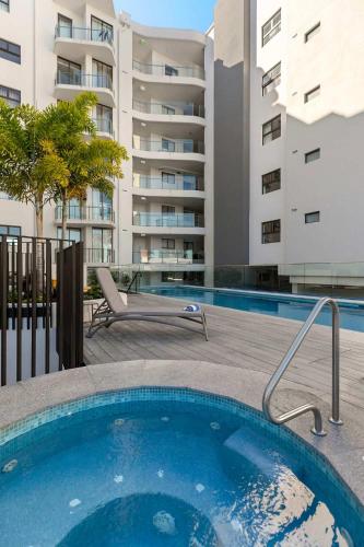 a swimming pool in front of a apartment at The Cosmopolitan Suite in Maroochydore