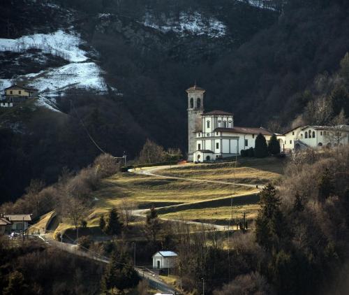 a large white house on a hill with a mountain at Aria Fresca in Sovere