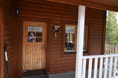a woman is looking out the door of a cabin at Skogshotell in Koskullskulle