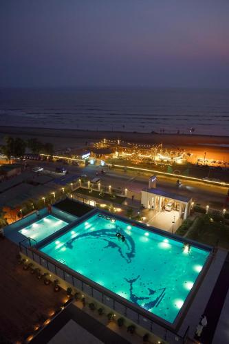 a large swimming pool at night next to the ocean at BAYWATCH Cox's Bazar in Cox's Bazar