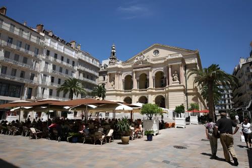 a group of people walking in a plaza in front of a building at Escale Toulonnaise - Cosy, calme & bien situé in Toulon