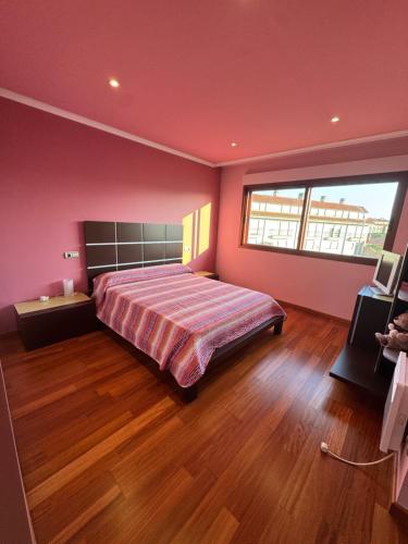 a bedroom with a bed and a large window at Playa Castro in Aguiño