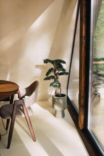 a room with a table and a bonsai tree on a wall at Juniper Chalet Mátra in Mátraszentimre