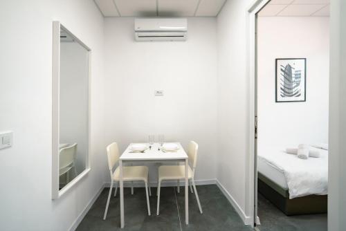 a dining room with a table and chairs and a bed at TQ City Apartments in Radanovići