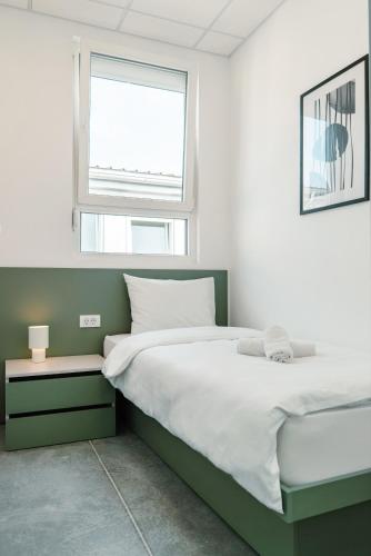 a bedroom with a large bed and a window at TQ City Apartments in Radanovići