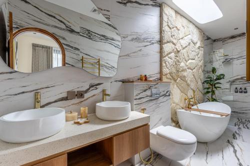 a bathroom with two sinks and a mirror at Villa Tofino Premium by Tofino Villas in Uluwatu