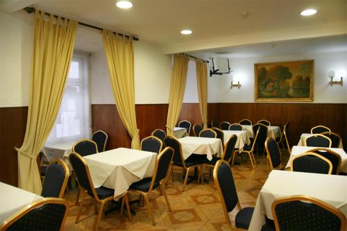 una sala da pranzo con tavoli e sedie bianchi di Pensao Nova Goa a Lisbona