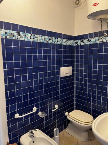 a blue tiled bathroom with a toilet and a sink at Monolocale Solana 6 in Cavo