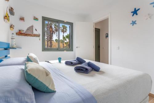 a bedroom with a large bed with blue towels on it at Casa Del Caballero Corralejo in Corralejo