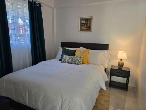 una camera da letto con un grande letto bianco e una finestra di Cosy Homes in Suva - Home That Hugs You! a Suva