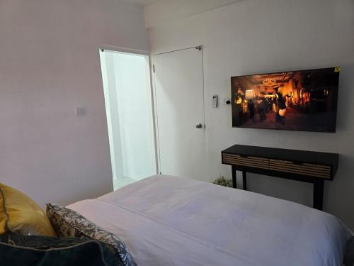 a bedroom with a bed and a tv on the wall at Cosy Homes in Suva - Home That Hugs You! in Suva
