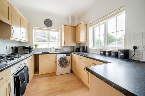 a large kitchen with a washer and dryer in it at MODERN 2 BED APARTMENT LOCATED CHINEHAM BUSINESS PARK with FREE PARKING, WIFI, NETFLIX BY AI ESTATE GROUP in Basingstoke