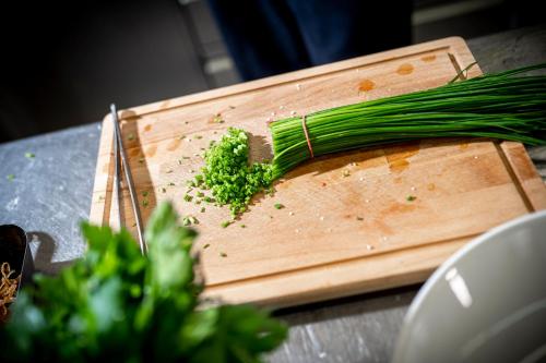 a bunch of green onions on a cutting board at Zum Fischer am See ***S in Prien am Chiemsee