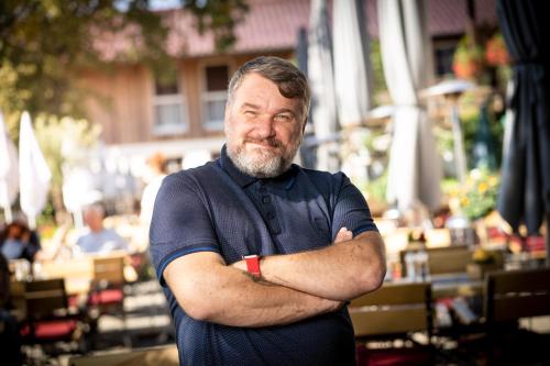 a man is standing with his arms crossed at Zum Fischer am See ***S in Prien am Chiemsee