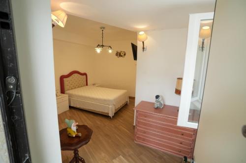 a small bedroom with a bed and a dresser at Praialonga Suites with Pool and Garden in Le Castella