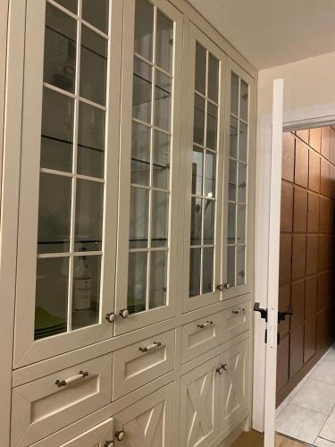 a large white cabinet with glass doors in a room at Main apartment Rezidenca in Tirane