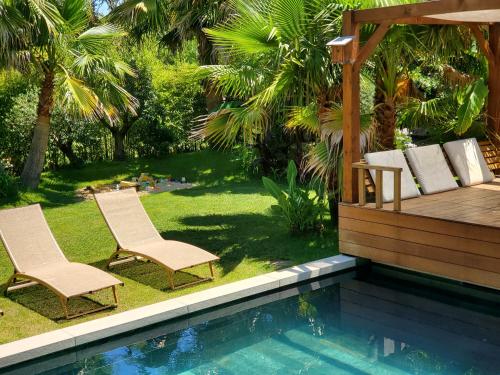 two chairs sitting next to a swimming pool at Luxury Bali Villa in Hossegor 5 stars- Pool & Petanque in Hossegor