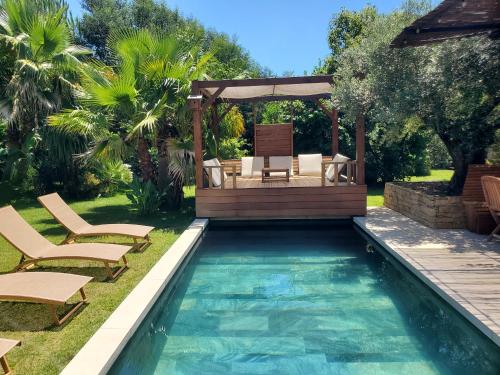 a backyard pool with a gazebo and a swimming pool at Luxury Bali Villa in Hossegor 5 stars- Pool & Petanque in Hossegor