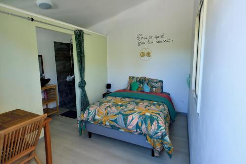 a bedroom with a bed and a sign on the wall at La Maison Verte in Le Tampon