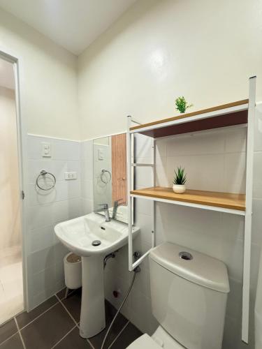 Un baño blanco con inodoro y lavabo. en Spacious Condo Studio Unit in Mactan Cebu, en Lapu Lapu City