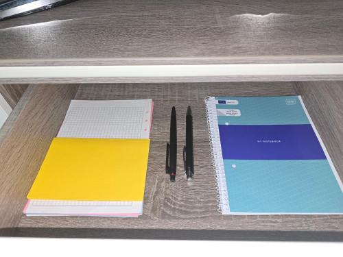 a desk with a notebook and pens on a table at Beethoven Apartments in Solingen