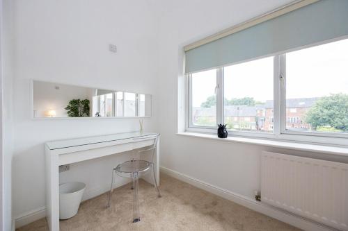 a white room with a desk and a window at Stylish 3 or 4 Bed House and Parking in Manchester