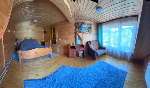 Лісова пісня في فيرخوفينا: غرفة بها سرير وكرسي وسجادة زرقاء