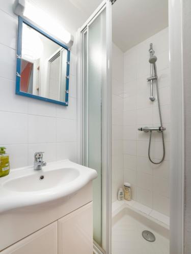 Un baño blanco con lavabo y ducha. en La Bergerie du Manoir de Kercassier Guérande, en Guérande