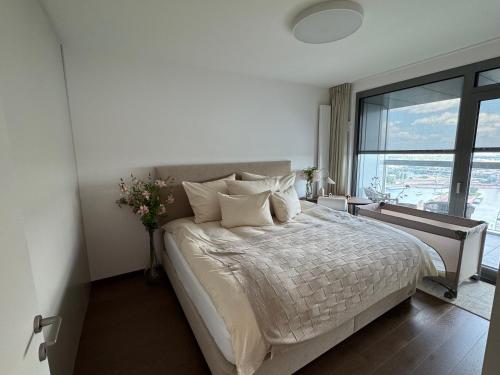 een slaapkamer met een groot bed met een groot raam bij Luxury Apartment 34th Floor Eurovea Tower in Ovsište