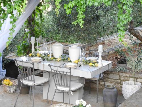 a white table with chairs and fruits on it at Apartments IVO in Stomorska