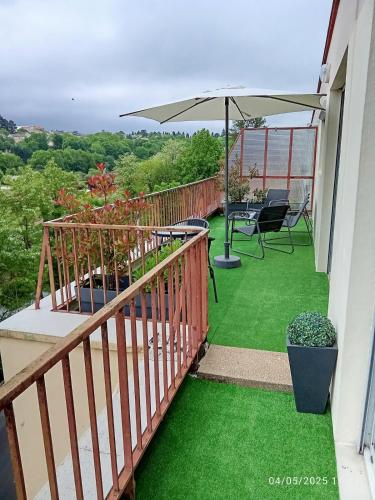 a balcony with a table and an umbrella at T2 - Terrasse avec vue imprenable - Secteur gare in Poitiers