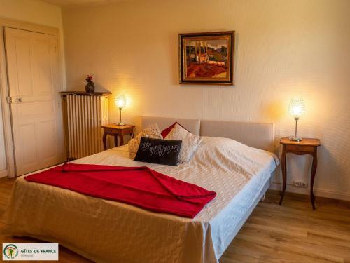 a bedroom with a bed with a red blanket on it at Gite de Conquettes in Canet-de-Salars