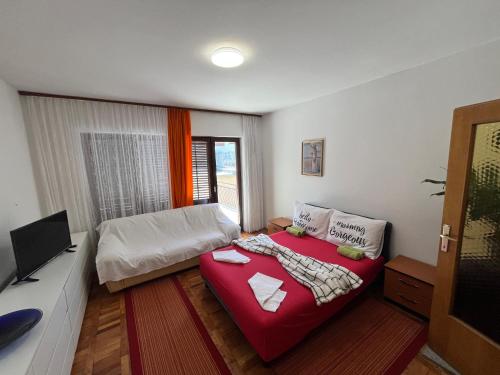 Cette petite chambre comprend un lit et une télévision. dans l'établissement Apartman Ramiza, à Jadranovo