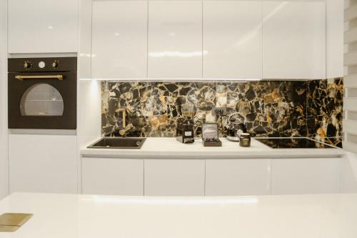 a white kitchen with a sink and a stove at ΔVO luxury apartment in Agios Nikolaos