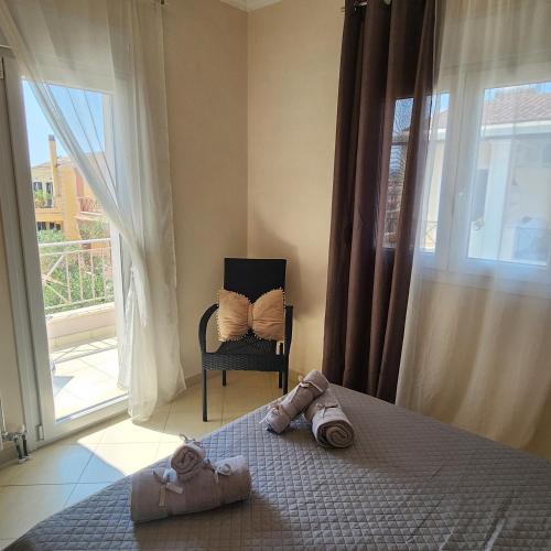 a bedroom with a bed and a chair and a window at Potamos Townhouse & Shared Garden in Potamós