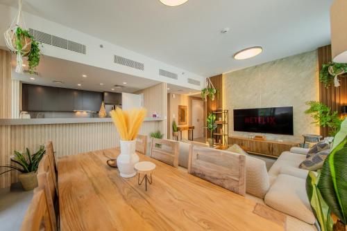 a living room with a couch and a table at 2BR Aljada Apartment - Forest Themed - Sleeps 6 - Balcony in Sharjah