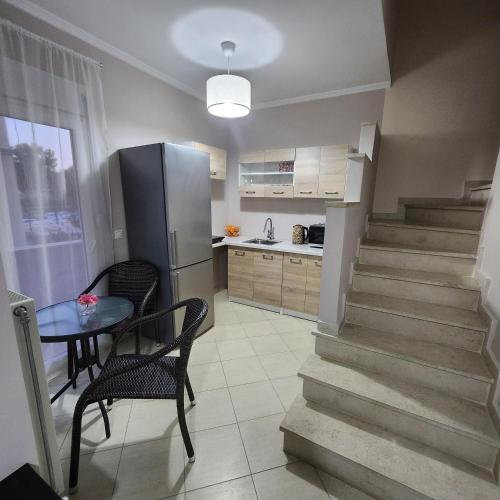 a kitchen with a staircase and a table and a refrigerator at Potamos Townhouse & Shared Garden in Potamós