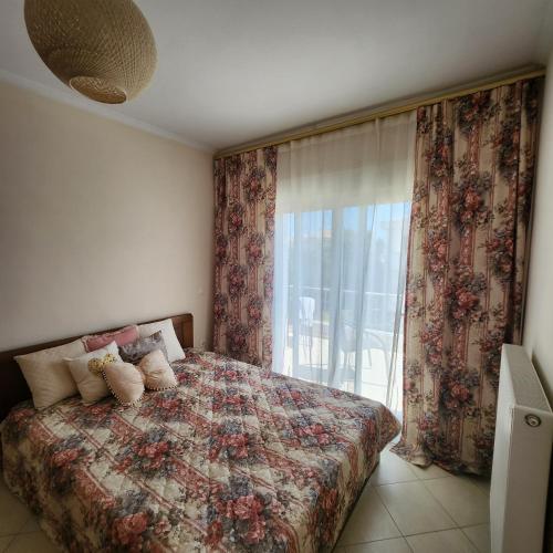 a bedroom with a bed with pillows and a window at Potamos Townhouse & Shared Garden in Potamós