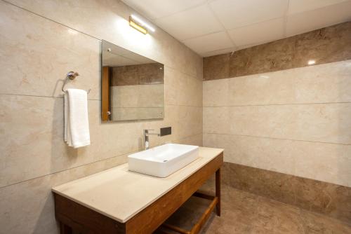 a bathroom with a sink and a mirror at Nexstay De' Malabaricus in Kozhikode