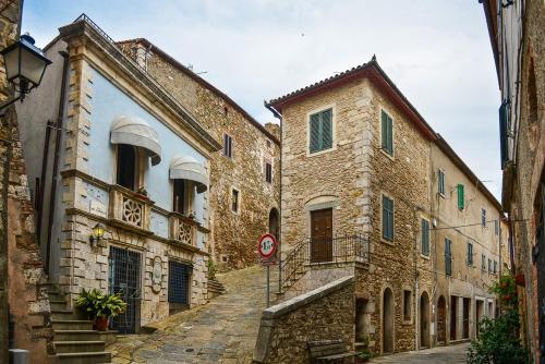 an alley in an old town with stone buildings at La Gatta in Montemerano
