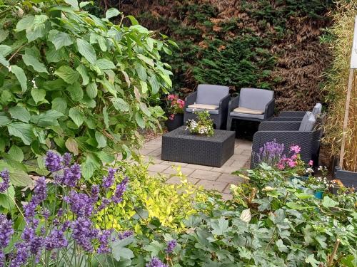 two chairs in a garden with flowers and plants at Bed & Breakfast de Koepeltjes in Zoetermeer