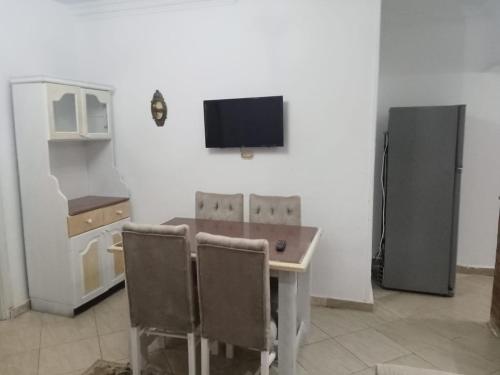 エル・アラメインにある1or2 Ground Chalets 2 Bedrooms villa114 Green Beachのテーブルと冷蔵庫のあるキッチン